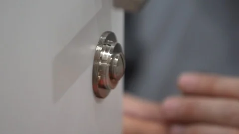 A man's hand twists the door lock into the door Stock Footage 104028229