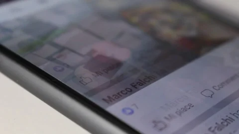 Man's hand types on the Facebook app on a smartphone Stock Footage 126406534