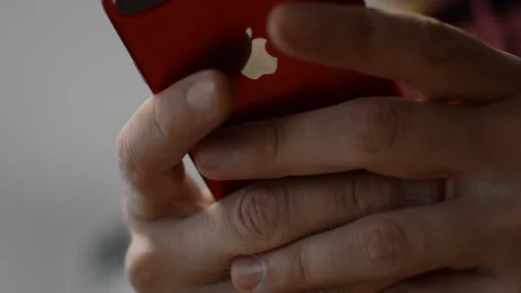 Man's hand typing on his iphone by apple. iphone device with apple logo. Stock-Footage 238786546