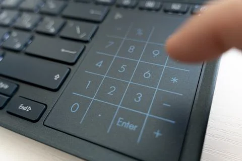 Man's hand typing on Numeric keypad of the black computer keyboard. Close-u.. Stock Photos
