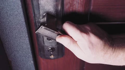 A man's hand unlocks the latch and enters the door. 库存影片 171344919