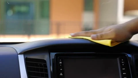 Man's hand used a yellow microfiber cloth to clean the console inside the car. T Stock Footage 152747927