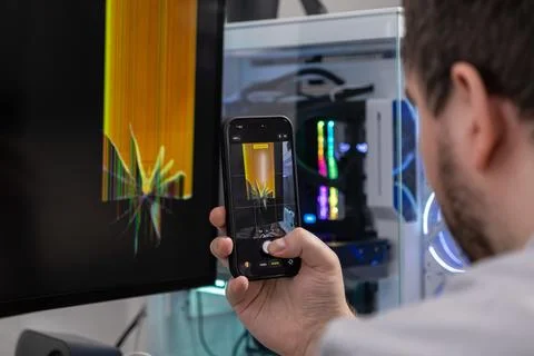 Man's hand uses smartphone camera to capture a broken computer monitor scre.. 스톡 사진