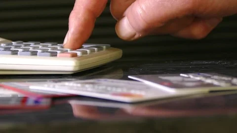 Man’s hand using a calculator. Cards in the foreground. Stock Footage 70619844