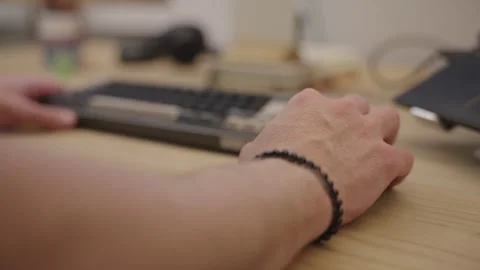 Man's hand using a computer mouse on a wooden desk with a mechanical keyboard in Stock Footage 335206326