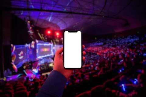 Man's hand using digital application on the mobile smart phone at esport event Stock Photos
