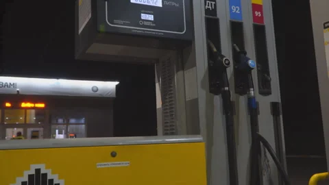 Man's hand using a fuel nozzle at a gas station in the evening Stock Footage 170922256