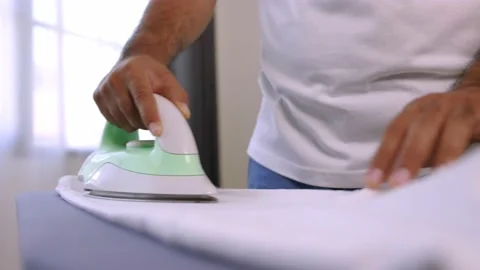 A man's hand using an iron. Iron the garment to make it smooth. Pictures about h Stock Footage 152748840
