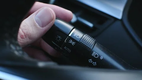 Man's hand, using the light switch knob, switches the car's lights to auto .. Stock Footage 287297109
