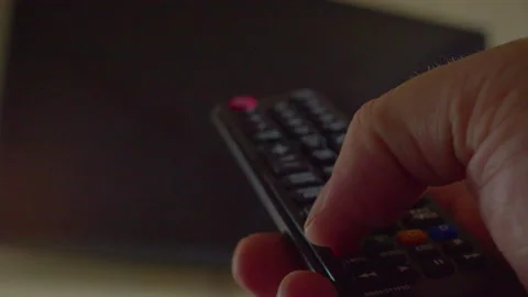 A man's hand using a remote control to navigate a TV menu, close-up57 動画素材 335648657