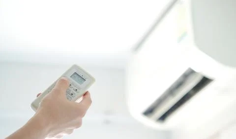 Man's hand using remote control open The air conditioner is cooled to 25 degr Stock Photos