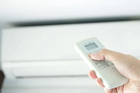 Man's hand using remote control open The air conditioner is cooled to 25 degr Stock Photos