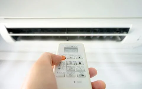 Man's hand using remote control open The air conditioner is cooled to 25 degr Stock Photos