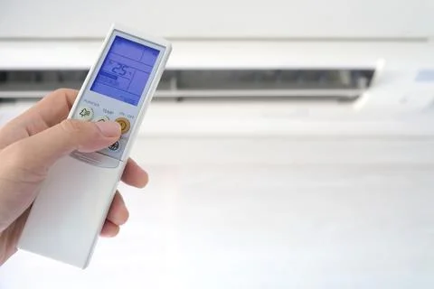 Man's hand using remote control open The air conditioner is cooled to 25 degr Stock Photos