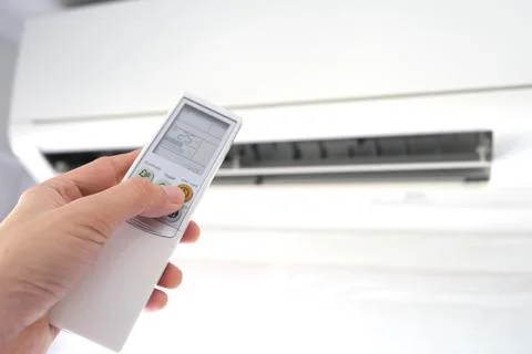 Man's hand using remote control open The air conditioner is cooled to 25 degr Stock Photos