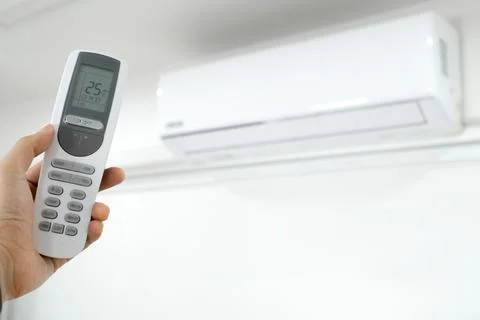 Man's hand using remote control open The air conditioner is cooled to 25 de.. Stock Photos