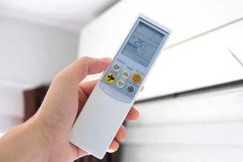 Man's hand using remote control open The air conditioner is cooled to 25 de.. Stock Photos