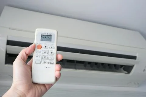 Man's hand using remote control open The air conditioner is cooled to 25 de.. Stock Photos