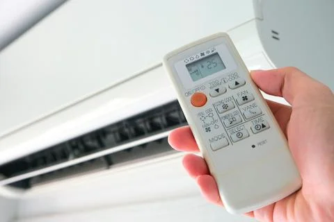 Man's hand using remote control open The air conditioner is cooled to 25 de.. Stock Photos