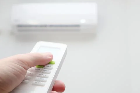 Man's hand using remote controler. Hand holding remote and adjusting temperat Foto stock