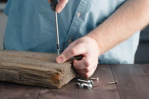 Man's Hand Using Screw Driver Assembling Wooden plank Foto stock
