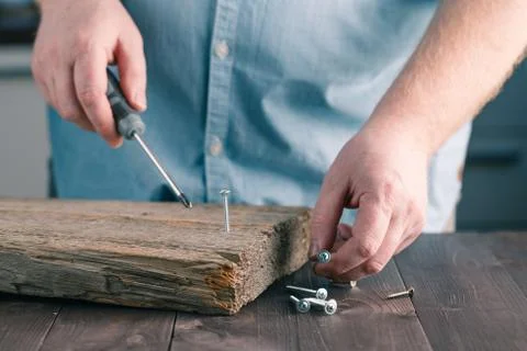 Man's Hand Using Screw Driver Assembling Wooden plank Foto stock