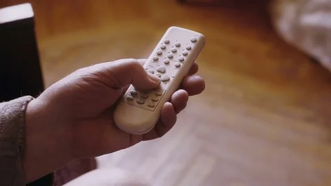 Mans hand using television tv remote control. Close up shot Stock Footage