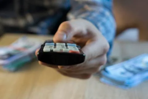 Man's hand using the tv remote control from the bed Foto stock