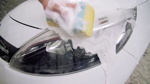 Man's hand washes the car headlight. Concept of Auto service, Stock Footage 131216332