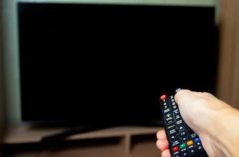 Man's hand while changing TV channels Stock Photos