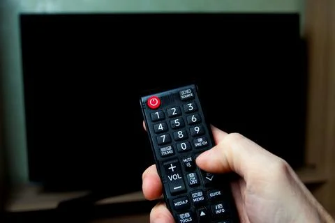 Man's hand while changing TV channels Stock Photos