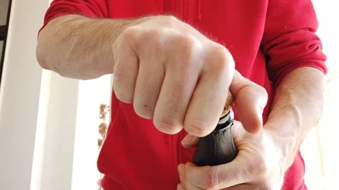 A man's hand while uncorking a bottle of champagne Vídeo Stock 128155288