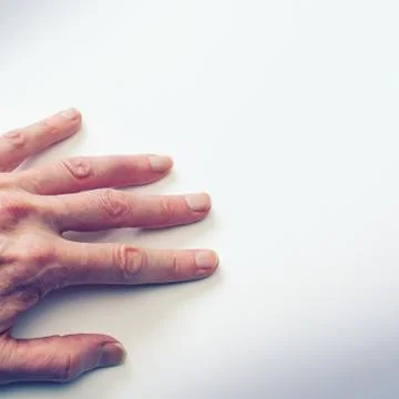 Man’s hand on white wall. Stock Photos