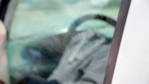 A man's hand wipes the driver's door glass with a leather rag. Stock Footage 158644359