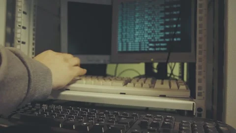 Man's hand works on two old-fashioned computer keyboards with an old interface Video stock 245959921