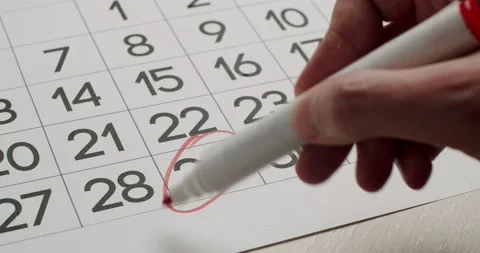 Man's hand Write down the 29th day on the paper calendar using a red pen. Stock Footage 197772775