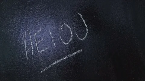 Mans hand writes AEIOU on a blackboard Stock Footage 84631383
