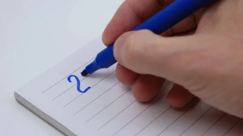 Man's hand writes the numbers of 2023 with blue felt-tip pen in a notebook. 4k. Stock Footage 200095571