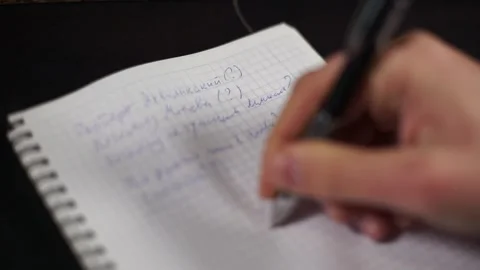 A man's hand writes a text on a notebook sheet. Vídeos de archivo 170874217