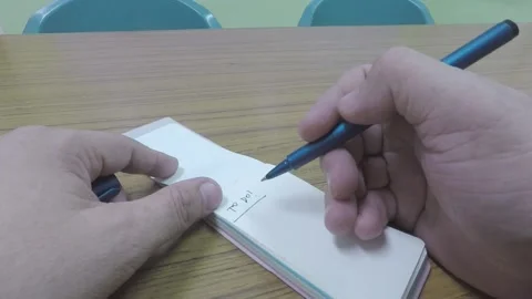 MAN'S HAND WRITING A TO DO TASK LIST ON A NOTEPAD ON WOODEN TABLE Stock Footage 133634423