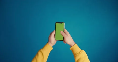 A man's hand in a yellow sleeve scrolls the tape on the smartphone screen Stock Footage 149742302