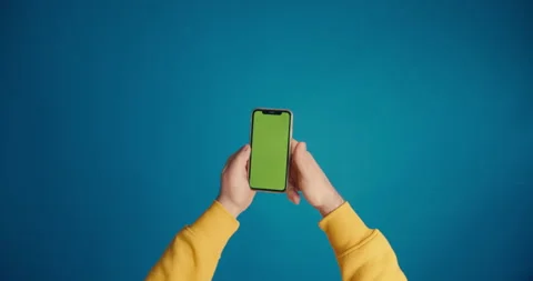 A man's hand in a yellow sleeve scrolls the tape on the smartphone screen Video stock 149743066