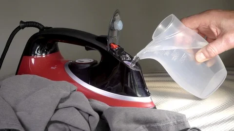 Man’s hands adding water to a clothes iron. Stock Footage 112334631