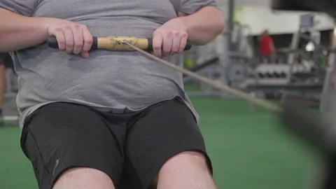 A Man's Hands and Belly While Operating a Rowing Machine Stock Footage 208739606