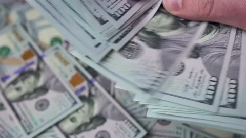 A man's hands are counting a thick stack of dollars Stock Footage 148957156
