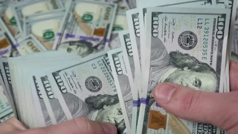 A man's hands are counting a thick stack of dollars Stock Footage 148957177