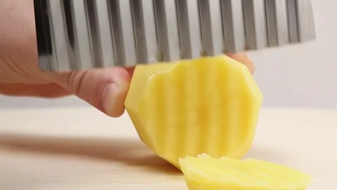 Man's hands are cutting potatoes into round slices with a knife for frying. Stock Footage 260195398