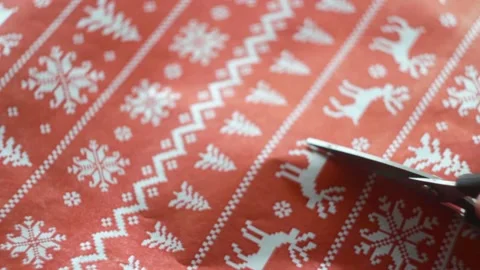 Man's hands are cutting red New Year's gift paper. Close-up. Stock Footage 143003566