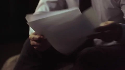 The man's hands are holding documents, the camera moves upwards Video stock 235350989