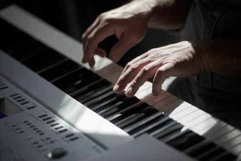 A man's hands are playing an electronic keyboard Stock Photos